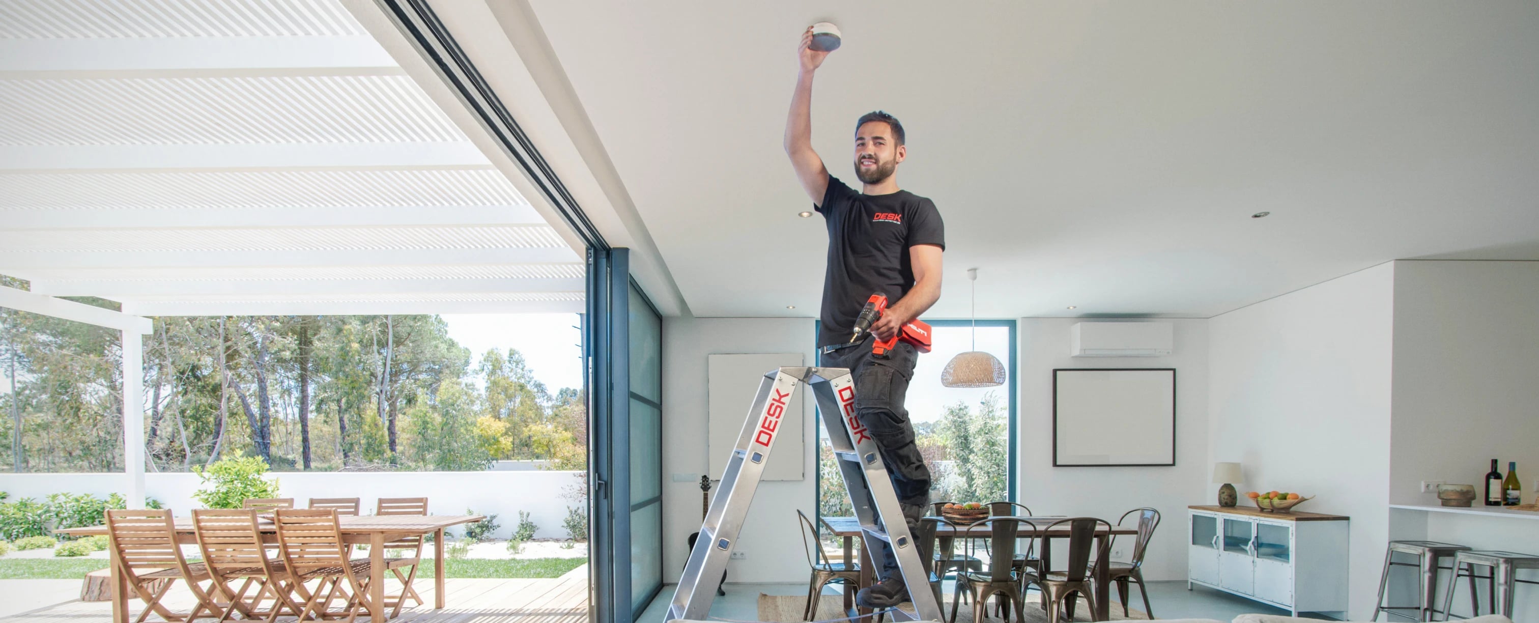 Sicherheitstechnik EMA Privatpersonen: Techniker installiert Melder in einem Wohnraum