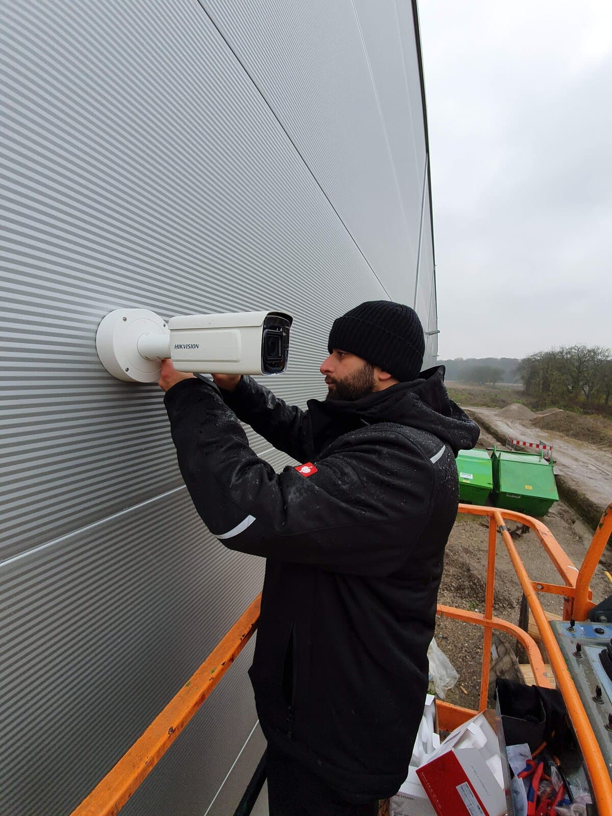 Montage einer Bullet-Überwachungskamera am Dachmast eines Industriegebäudes – Videoüberwachung mit Perimeterabdeckung für Gewerbe- und Logistikflächen in Karlsruhe